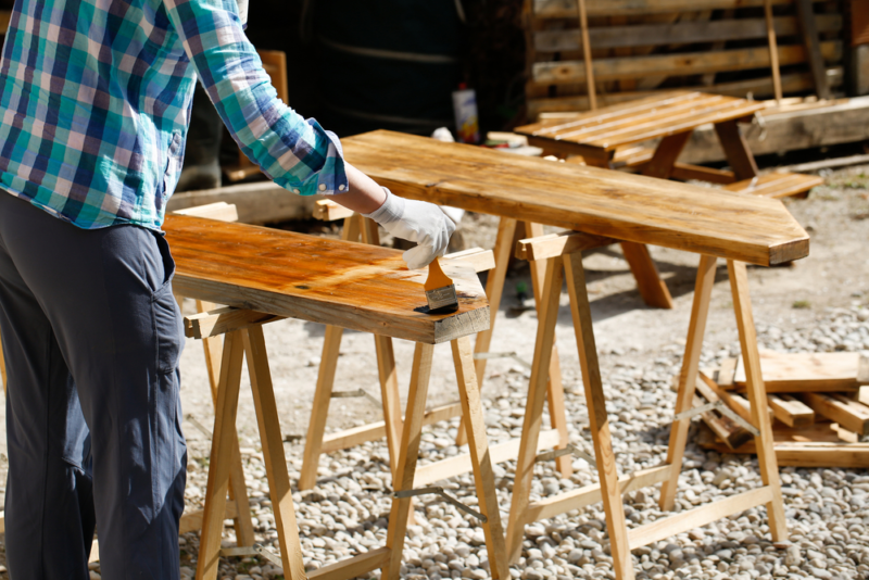 man applying the best outdoor wood finish
